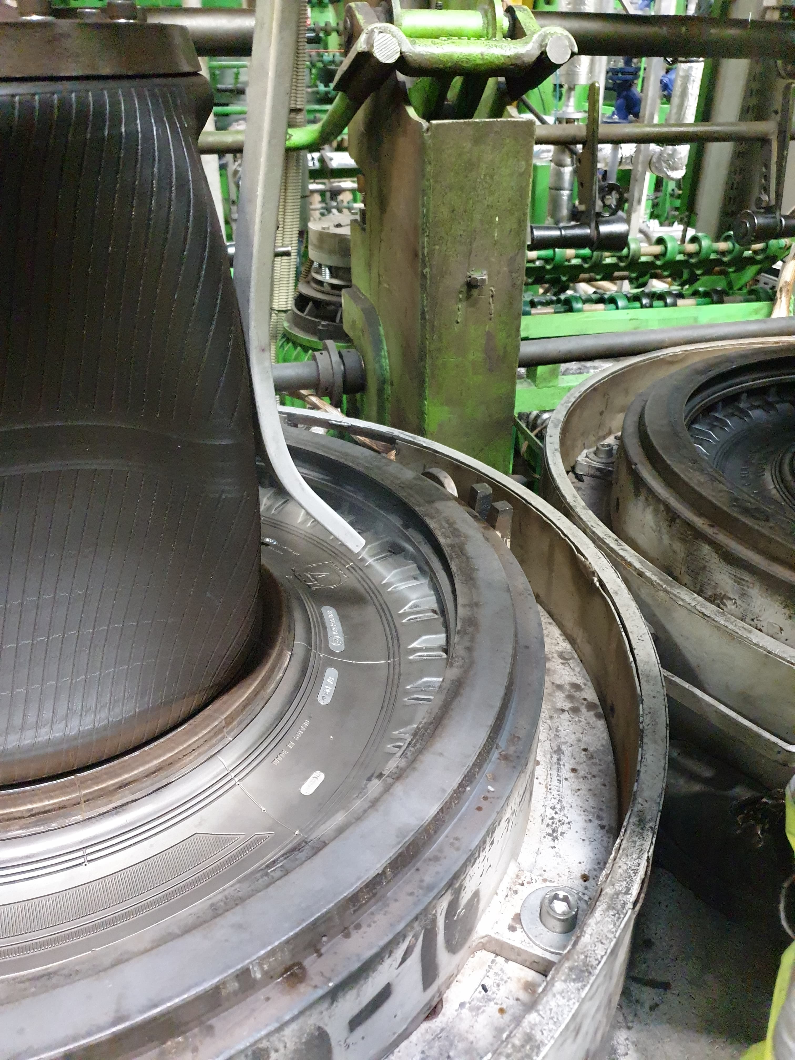 Close-up of tire mold cavity with inner bladder and vent ring in the press